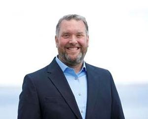 headshot of man with beard, wearing blue blazer and dress shirt