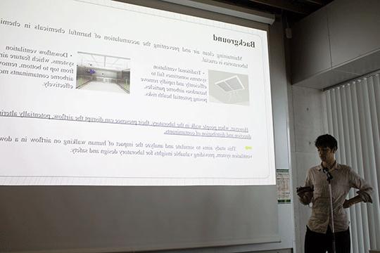 young man standing in front of screen giving presentation